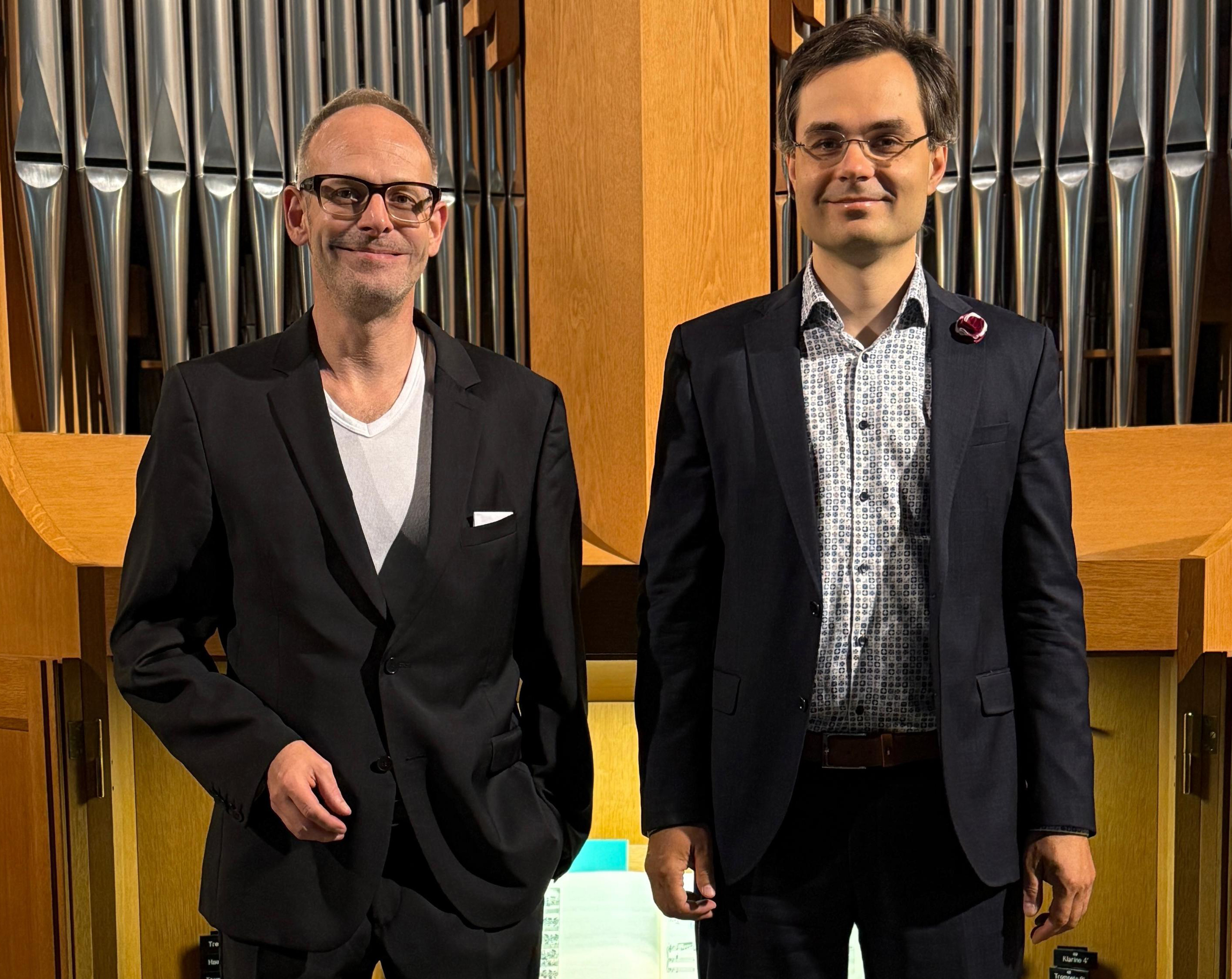 Die beiden Organisten stehen vor einer Orgel